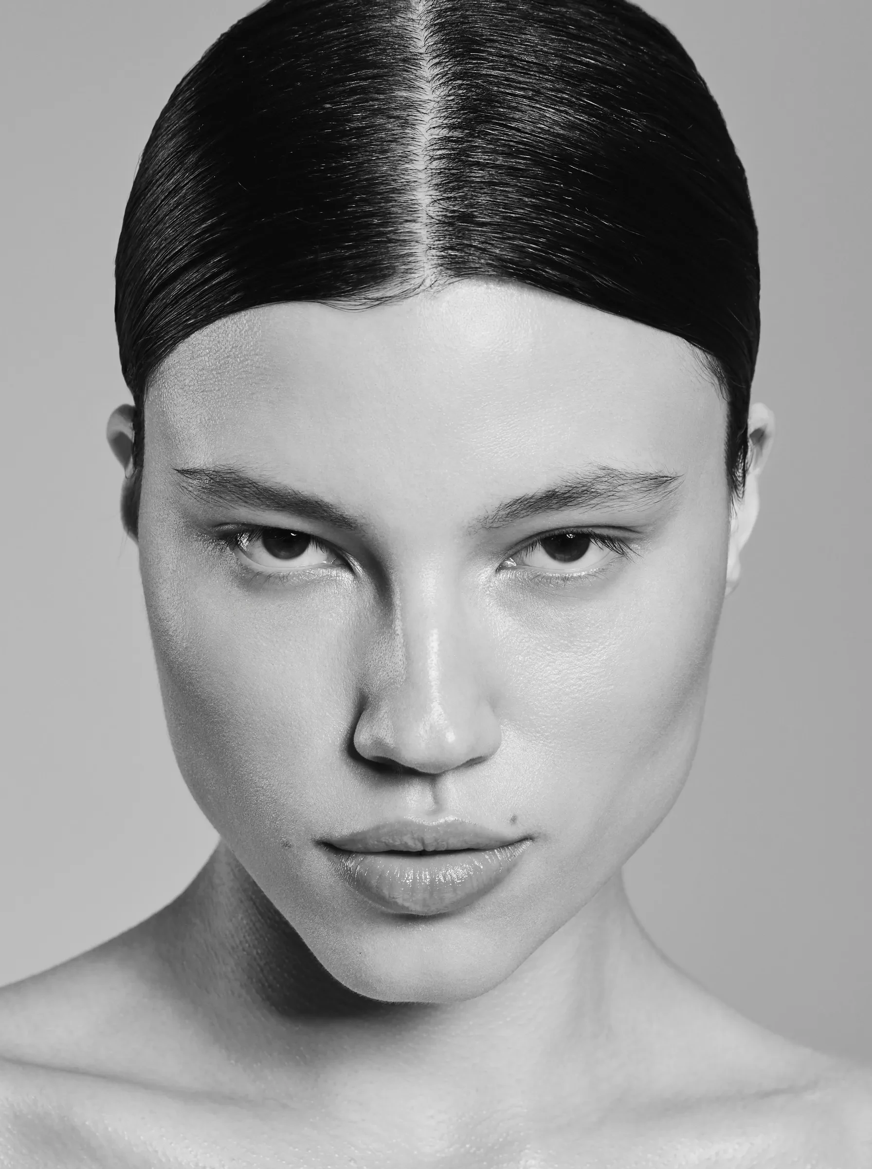 Black and white portrait, bare skin and slicked back hair